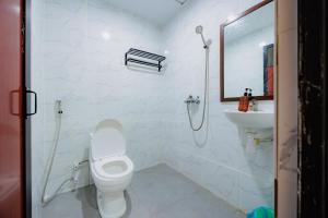 a white bathroom with a toilet and a sink at Sans Hotel Sedana Batam in Nagoya +29 photos