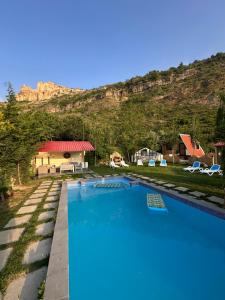 a swimming pool with a mountain in the background at arida farm peach in Bcharré