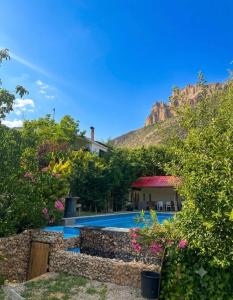 a villa with a swimming pool and a mountain at arida farm peach in Bcharré +8 photos