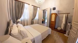 a bedroom with a white bed and a chandelier at "LOS" 2 Neoclassic Harbour View in Symi