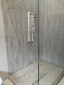 a shower with a glass door in a bathroom at Unitas Park B&B in Vereeniging