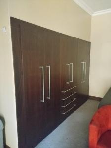 a wall with wooden cabinets in a room at Unitas Park B&B in Vereeniging