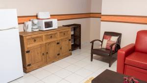 a living room with a microwave on a wooden cabinet at Maison charmante Le Moule + piscine in Le Moule