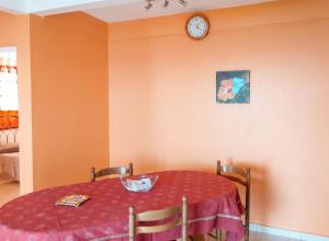 a dining room table with a clock on the wall at Appartement moderne avec vue mer à Bouillante, 50 m² in Bouillante +6 photos