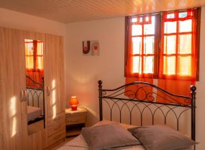 a bedroom with a bed and two windows at Appartement moderne avec vue mer à Bouillante, 50 m² in Bouillante