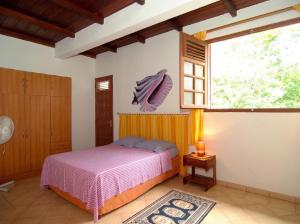 a bedroom with a bed and a window at Appartement accueillant au Robert avec balcon et jardin in Le Robert