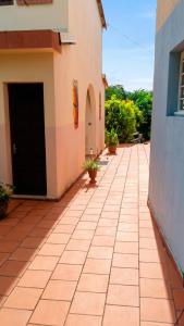 a tiled sidewalk next to a building with a black door at Appartement accueillant au Robert avec balcon et jardin in Le Robert