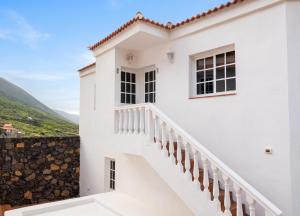 a white house with stairs and a stone wall at Cosy Studio with Sea View and Garden in Frontera - 20 m² in Frontera