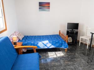 a living room with a bed and a blue couch at Cosy Studio with Sea View and Garden in Frontera - 20 m² in Frontera