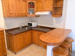 a kitchen with wooden cabinets and a sink and a microwave at Exceptional Studio in Frontera | 25 sq.m. | Terrace in Frontera