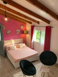 a bedroom with a bed and two chairs at Studio cosy à Capesterre-Belle-Eau avec terrasse in Capesterre-Belle-Eau