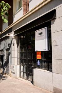 an entrance to a building with a sign on it at Medichë Rooms General Ricardos in Madrid