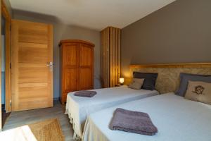 a bedroom with two beds and a wooden door at Gîte La Peyrolle in Aouste-sur-Sye