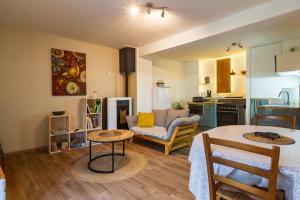 a living room with a table and a kitchen at Gîte La Peyrolle in Aouste-sur-Sye