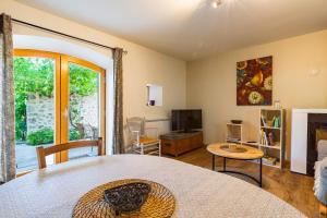 a bedroom with a bed and a living room with a fireplace at Gîte La Peyrolle in Aouste-sur-Sye