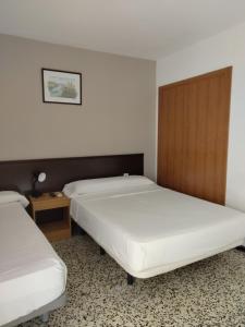 a bedroom with two beds and a wooden headboard at Hotel Iris in Benidorm