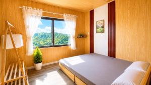 a bedroom with a bed and a ladder and a window at LaLa Hill in Ấp Kim Thạch