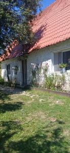 a white brick house with a red roof at Bjeshket e Thethit Hostel in Theth