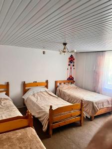 a room with three beds in a room at Bjeshket e Thethit Hostel in Theth