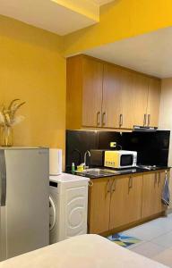 a kitchen with a white washer and a microwave at Shell Residences Tower A B in Manila