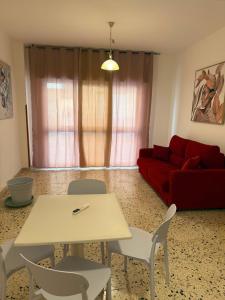 a living room with a table and a red couch at Il Rifugio della Grotta S.Ninfa in Santa Ninfa +42 photos
