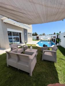 a patio with chairs and a swimming pool at Villa Luna in Hennchir Ksar Rhaleb