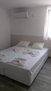 a white bed with white sheets and pillows in a room at Fani 2 in Lozenets