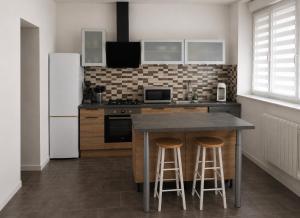 una cucina con frigorifero e tavolo con sgabelli di Worgot a Monthermé 1 altra foto