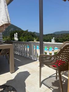 a rattan chair sitting on a balcony with a view at Lazaros in Ágios Matthaíos +36 photos