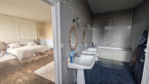 a bathroom with a sink and a toilet and a bed at L'héritage in Champdeniers