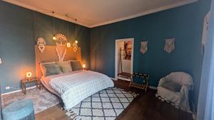a bedroom with a bed and a blue wall at L'héritage in Champdeniers