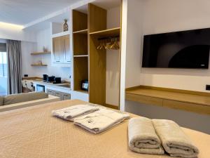 a room with a bed with two towels on a table at Marizon Suites - Adults Only in Vrachonisída touArchangélou