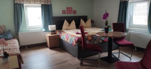 a bedroom with a bed and a table and chairs at Pension Pencik in Kurort Altenberg