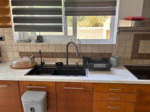 a kitchen with a sink and a stove and a window at Lazaros in Ágios Matthaíos