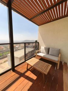 a porch with a couch and a bench on a balcony at בצלי-ה in Safed
