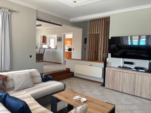 a living room with a couch and a flat screen tv at Lazaros in Ágios Matthaíos