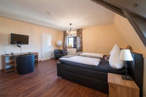 a bedroom with a bed and a desk and a television at Leipziger Hof in Fulda