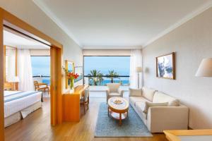 a living room with a couch and a bed and a table at Constantinou Bros Asimina Suites Hotel in Paphos