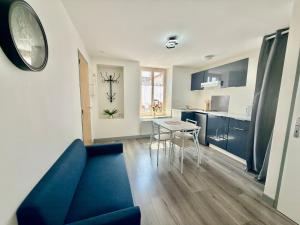 a living room with a blue couch and a table at T2 calme rue Pasteur appartement 1 - DABNB in Le Palais-sur-Vienne