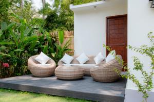 a patio with rattan furniture on a deck at Tropical Villa with Swimming Pool in Selong Belanak