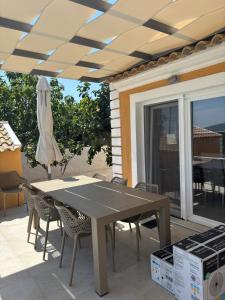 a table and chairs on a patio with an umbrella at Lazaros in Ágios Matthaíos