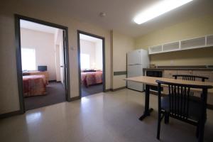 a kitchen with a table and a room with a bed at Residence & Conference Centre - Windsor in Windsor