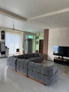 a living room with a large couch and a flat screen tv at Mandarini in Chakvi
