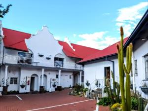 a large white building with a red roof at Rosahoff Guesthouse in Windhoek