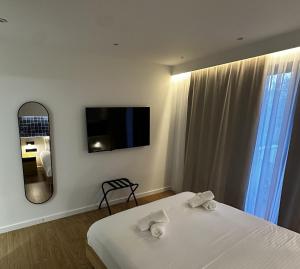 ein Schlafzimmer mit einem Bett, einem Spiegel und einem Fernseher in der Unterkunft Aetheria resort in Samothráki