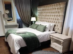 a bedroom with a large white bed with green pillows at Rosahoff Guesthouse in Windhoek +88 photos