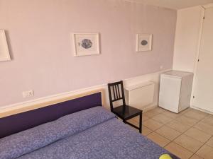 a bedroom with a purple bed and a chair at Calaluna in La Maddalena
