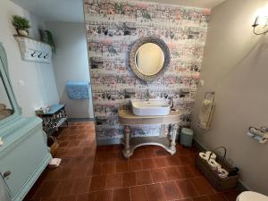 a bathroom with a sink and a mirror on a wall at La Clé D'Alice in Montmorillon
