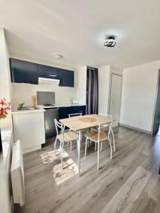 a kitchen and dining room with a table and chairs at T2 calme rue Pasteur appartement 1 - DABNB in Le Palais-sur-Vienne +2 photos