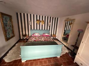 a bedroom with a bed and a striped wall at La Clé D'Alice in Montmorillon
